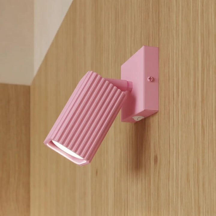 Lampe de bureau Rayo en aluminium rose à réflecteur rainuré sur une table d'appoint