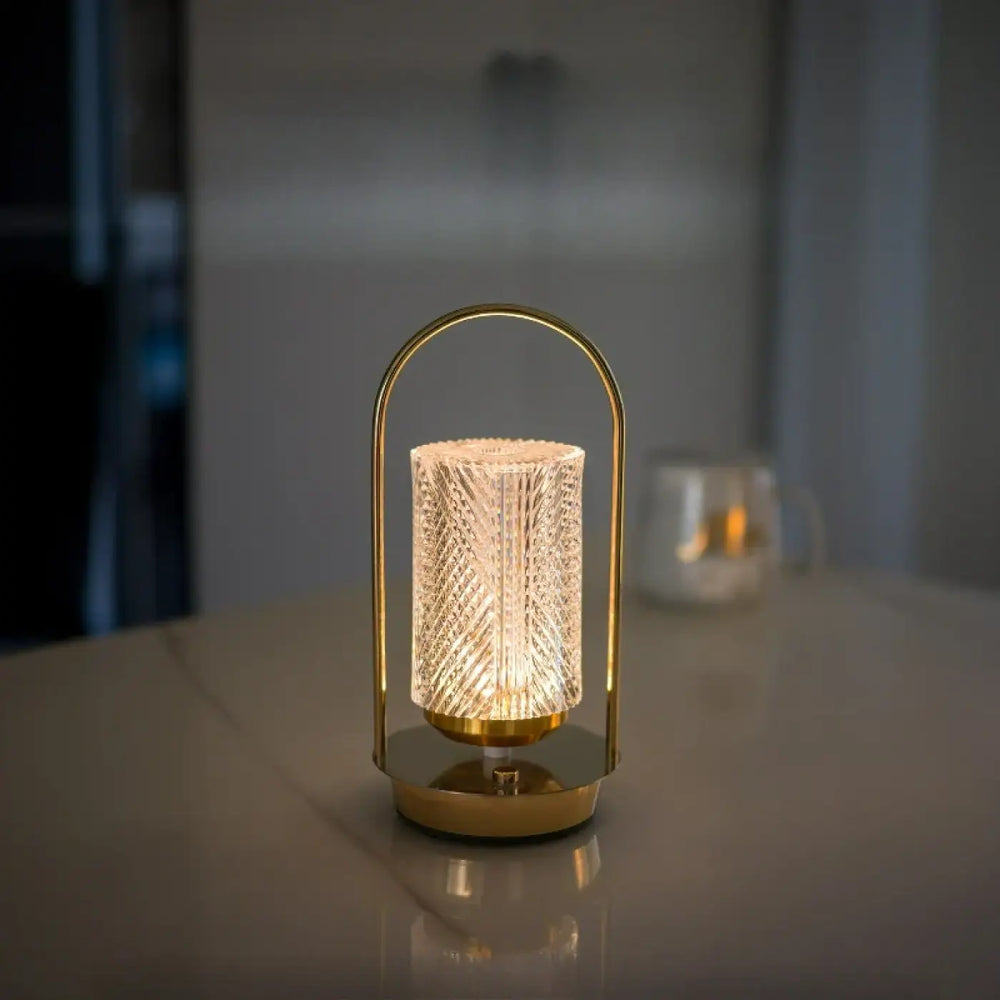 Lampe de chevet miu en métal doré avec verre translucide facetté et cadre arqué offrant un design élégant et une présence lumineuse
