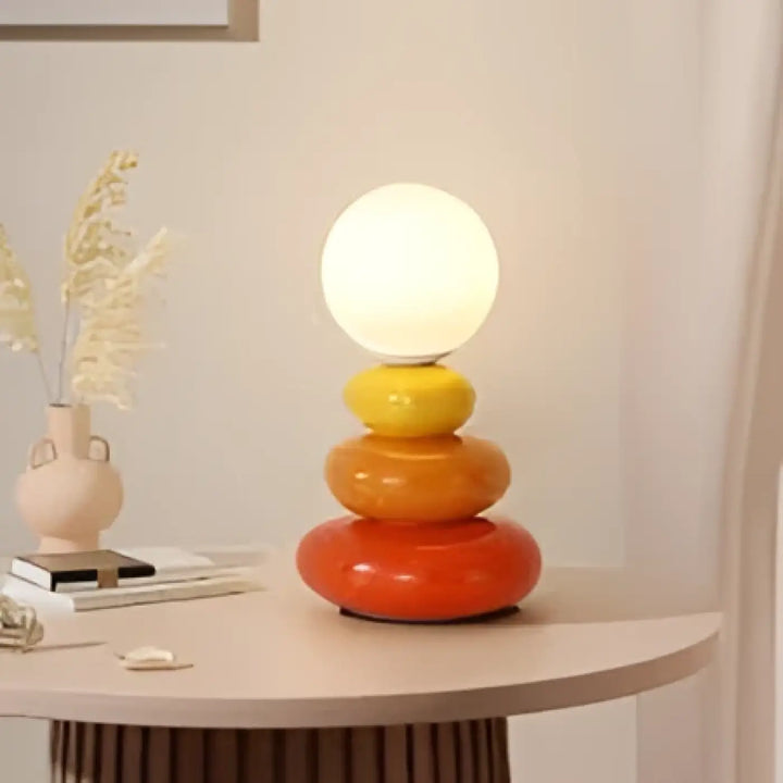 Lampe de chevet hestia design galets empilés avec globe blanc lumineux et anneaux concentriques jaune et orange