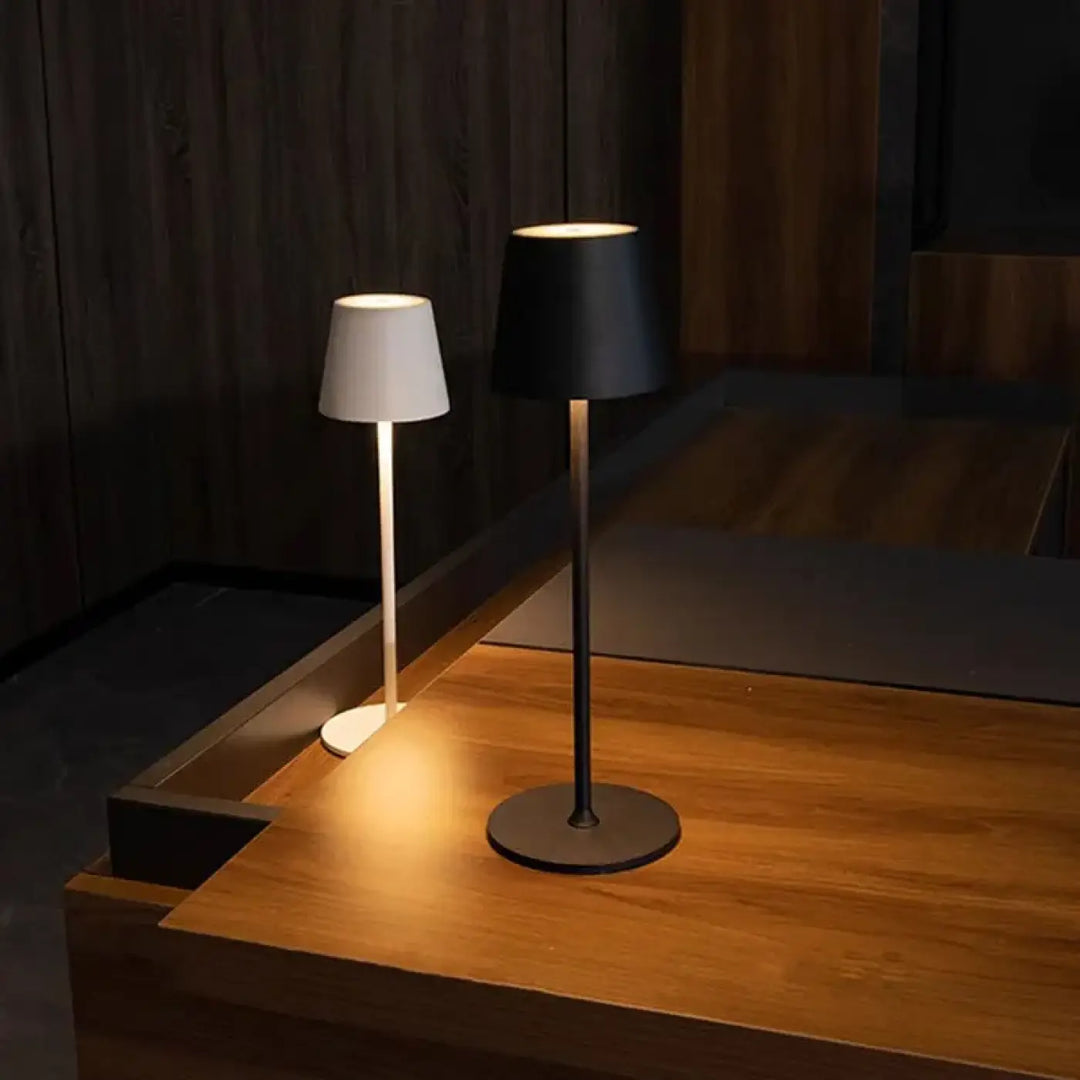 Deux lampes de chevet minimalistes avec abat-jours cylindriques blanc et noir sur tiges métalliques offrent un éclairage doux et une facilité dentretien