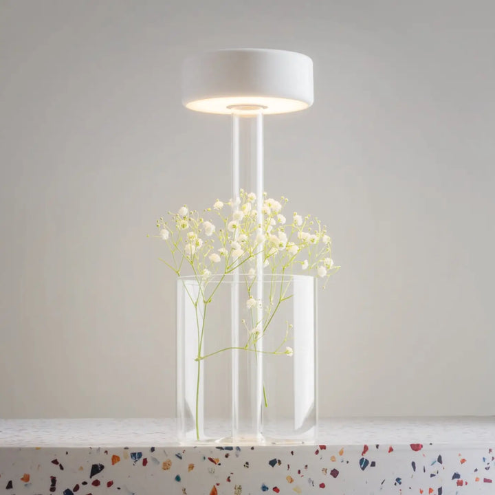 Lampe de chevet led dimmable blanche avec tige transparente sur vase en verre clair et décoration florale gypsophile