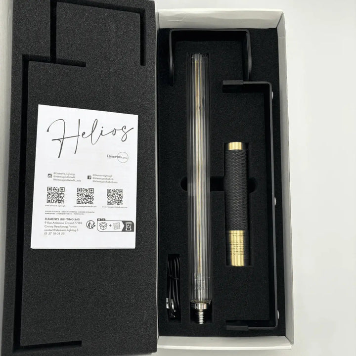 Lampe de chevet helios avec corps cylindrique transparent et poignée noire texturée comme objet lumineux led