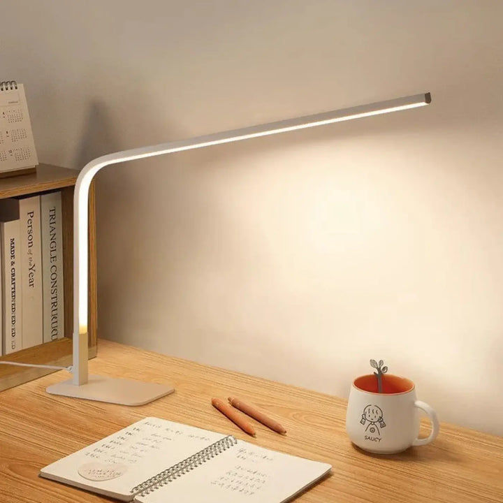 Lampe de table minini avec bras métallique courbé et barre led contemporaine émettant une lumière blanche chaude