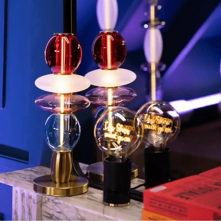 Lampe de chevet léonor avec globes en verre soufflé empilés rouges, bleus et clairs sur base métal doré