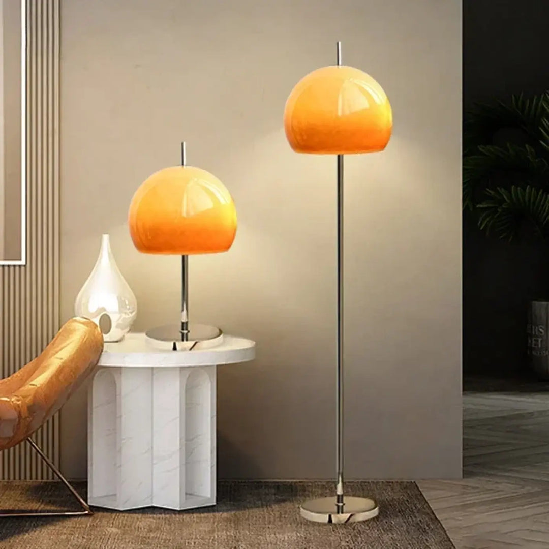 Lampadaire nectar avec pied moderne en chrome et abat-jour en verre dégradé orange diffusant une lumière douce