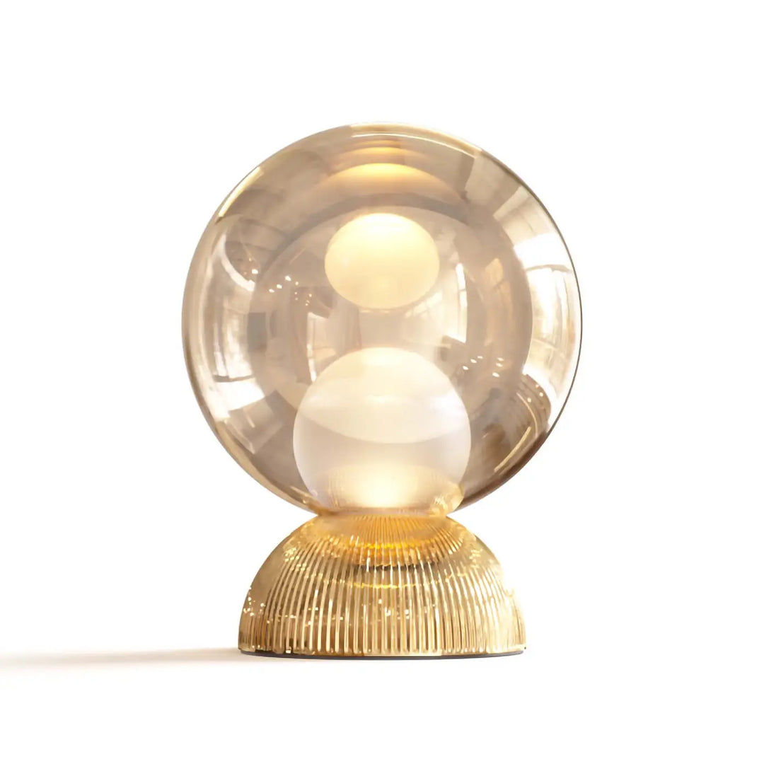 Lampe de chevet poser charm avec sphère lumineuse cachée dans un globe compact en verre ambré sur base dorée texturée