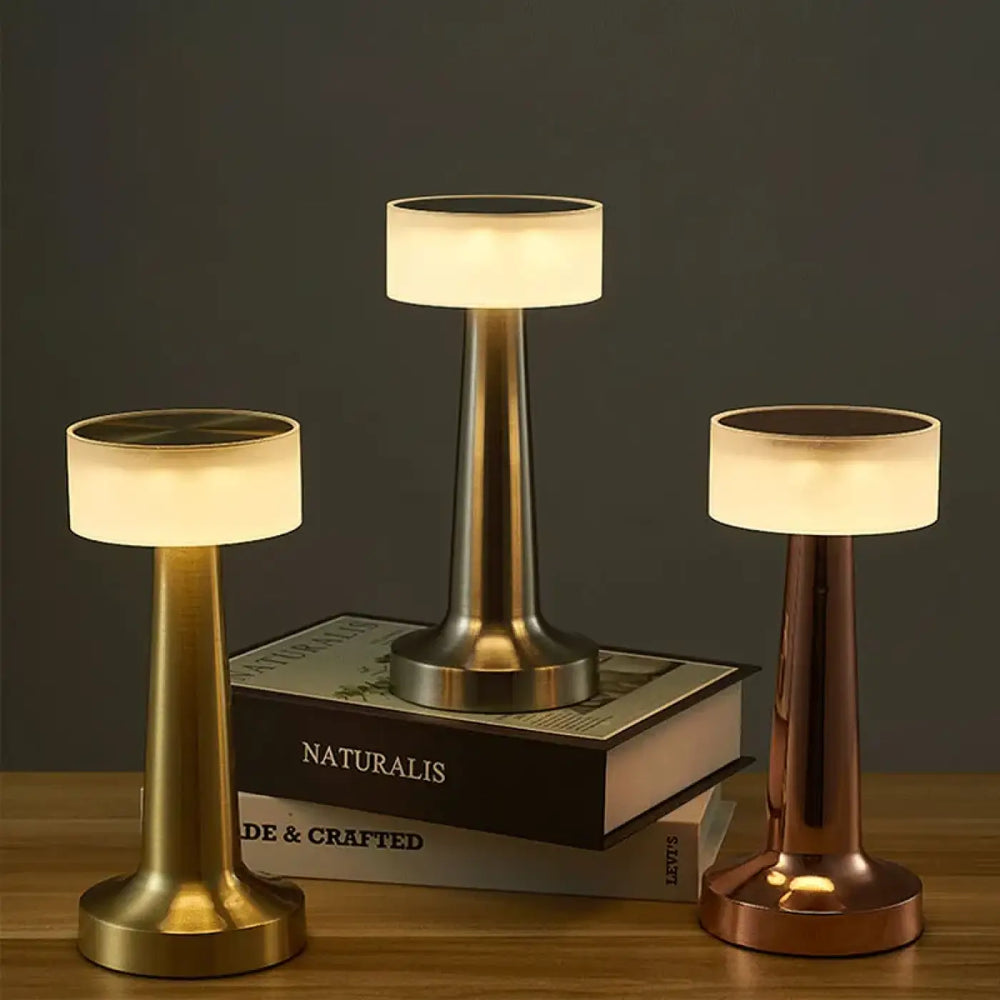 Lampe de table ninou design minimaliste avec abat-jour cylindrique en verre dépolie et base métallique finition or laiton brossé cuivre variateur tactile pour décoration intérieure