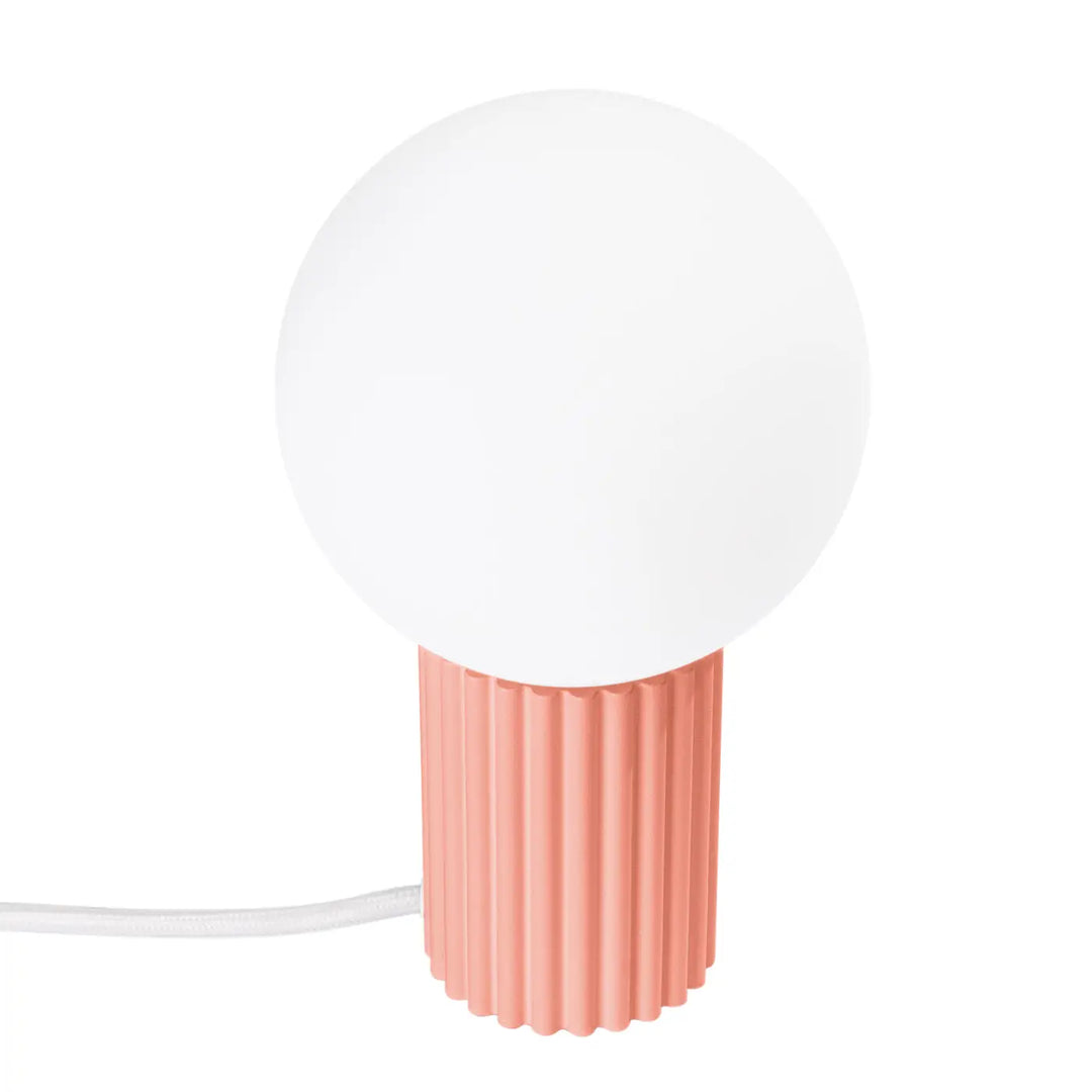 Lampe à poser halo peach avec abat-jour sphérique en verre dépoli blanc et base côtelée corail moderne