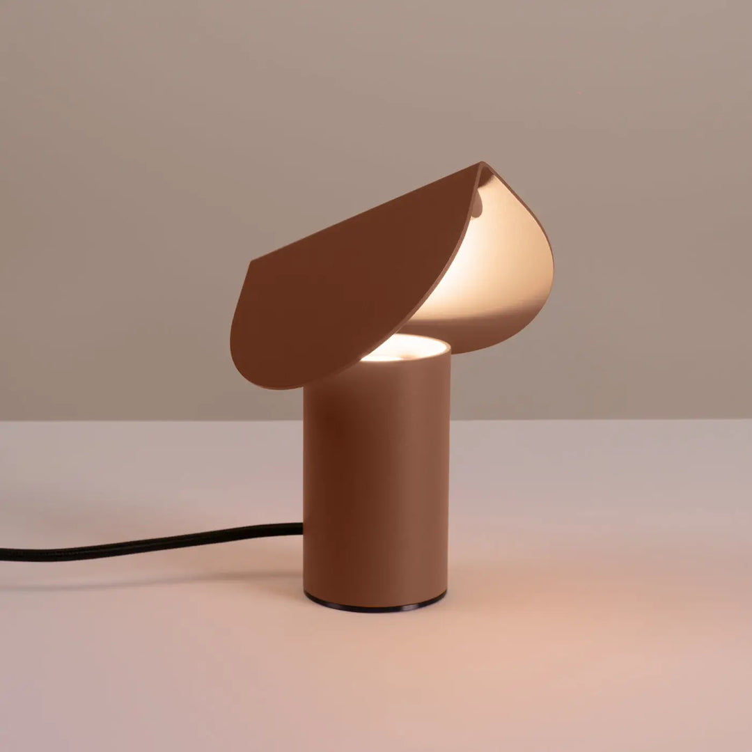 Lampe à poser BISCUIT moka allumée, sur une table