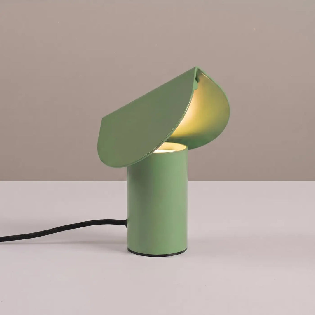 Lampe à poser BISCUIT sauge allumée, sur une table