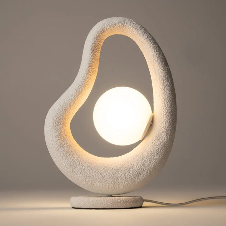Lampe à poser blanche en céramique texturée avec socle sculptural et bulbe circulaire lumineux objet d’art opus wabi-sabi