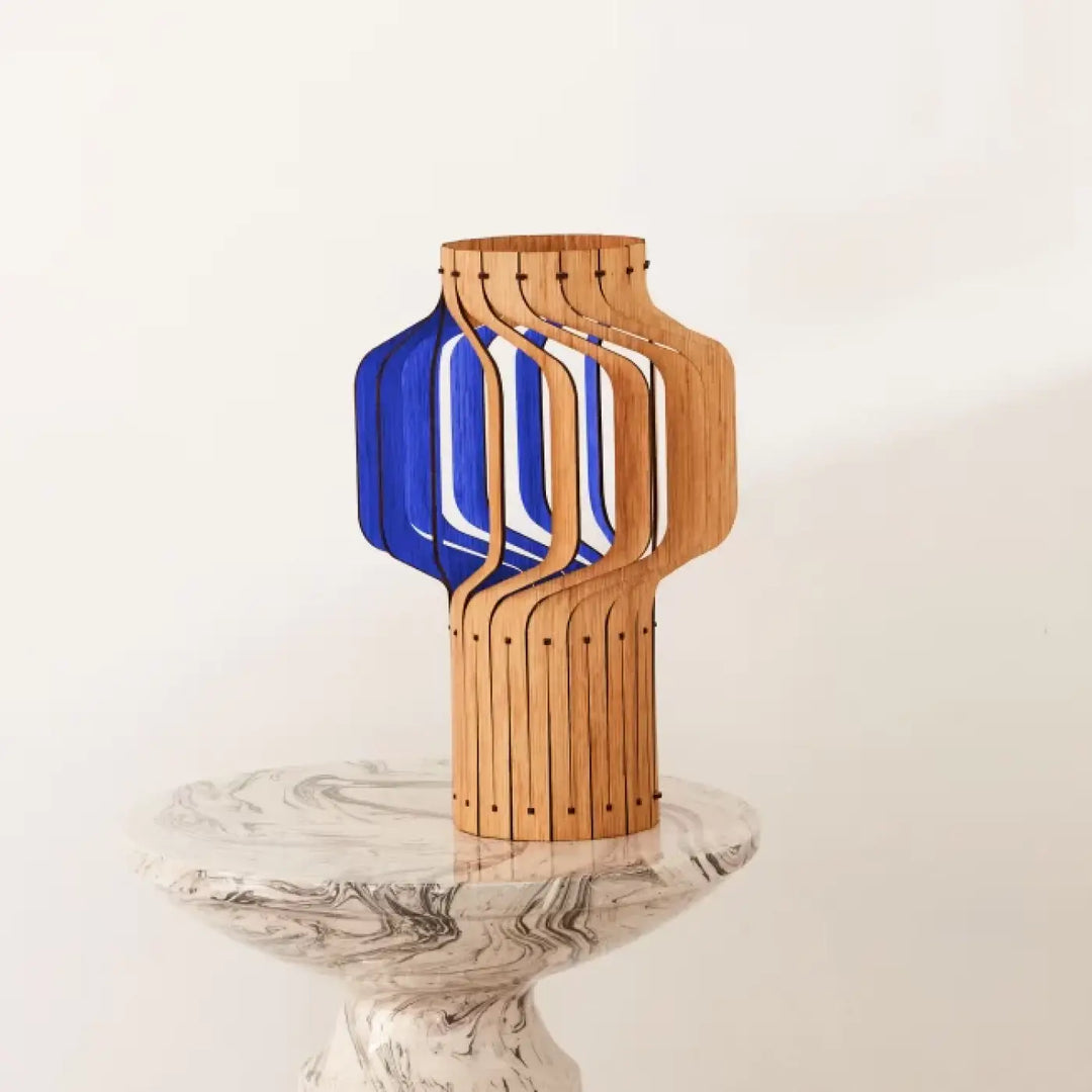 Lampe à poser tjinkwe fråd en bois fsc avec insert en verre bleu et accents métalliques verticaux
