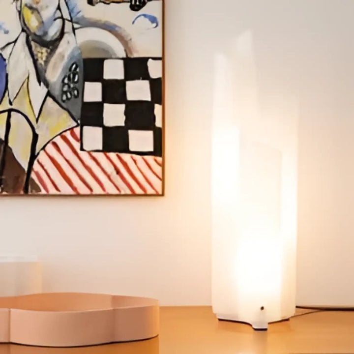 Lampe de table folda au corps translucide blanc aux lignes plissées diffusant une lumière douce et chaleureuse
