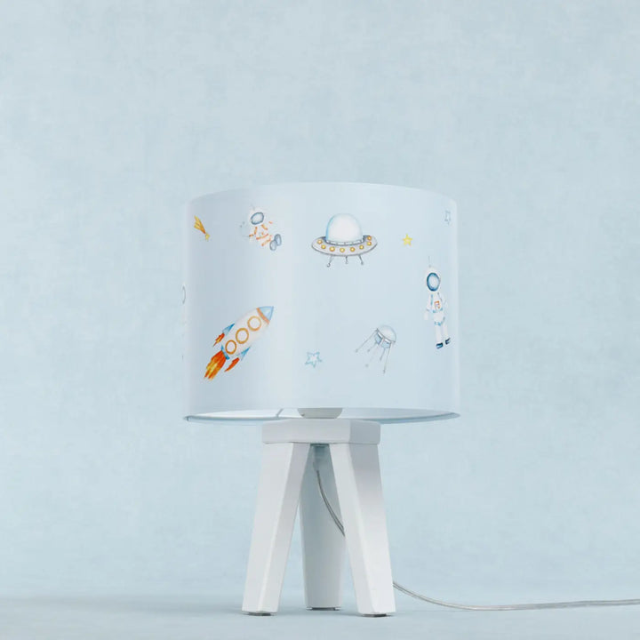 Lampe de table sweet dreams avec abat-jour cylindrique illustré espace coloré sur base minimaliste blanc table cosmique bleu enfant