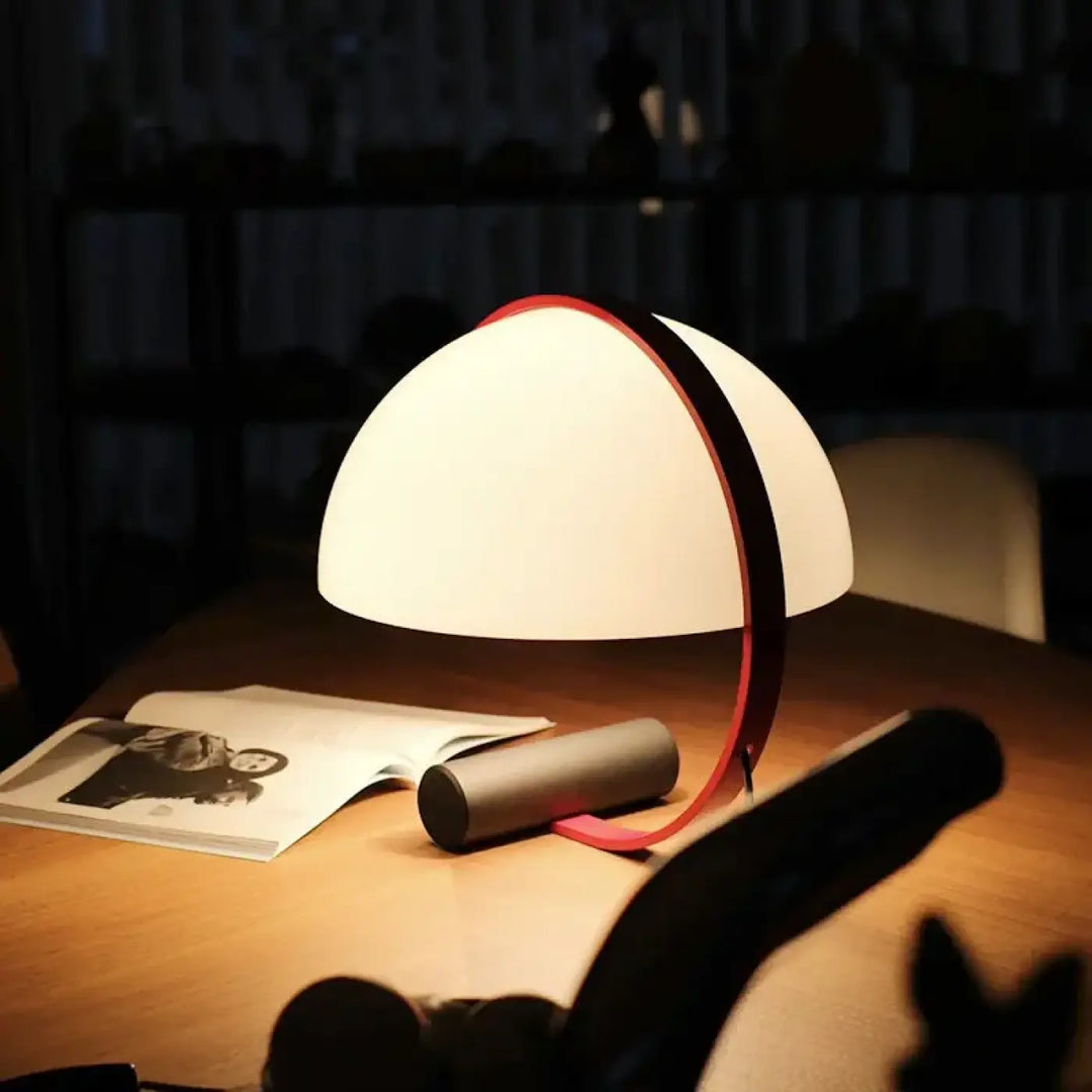 Lampe de table arcena en demi lune aux courbes blanches avec une bande rouge et éclairage d ambiance doux