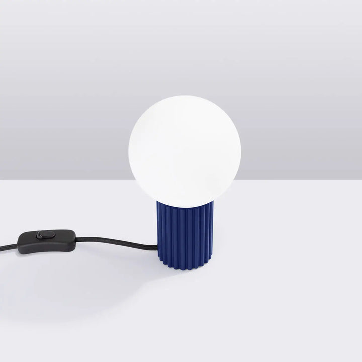 Lampe halo poser halo outremer avec base cylindrique côtelée bleu marine et ampoule sphérique blanche opaque version suspension