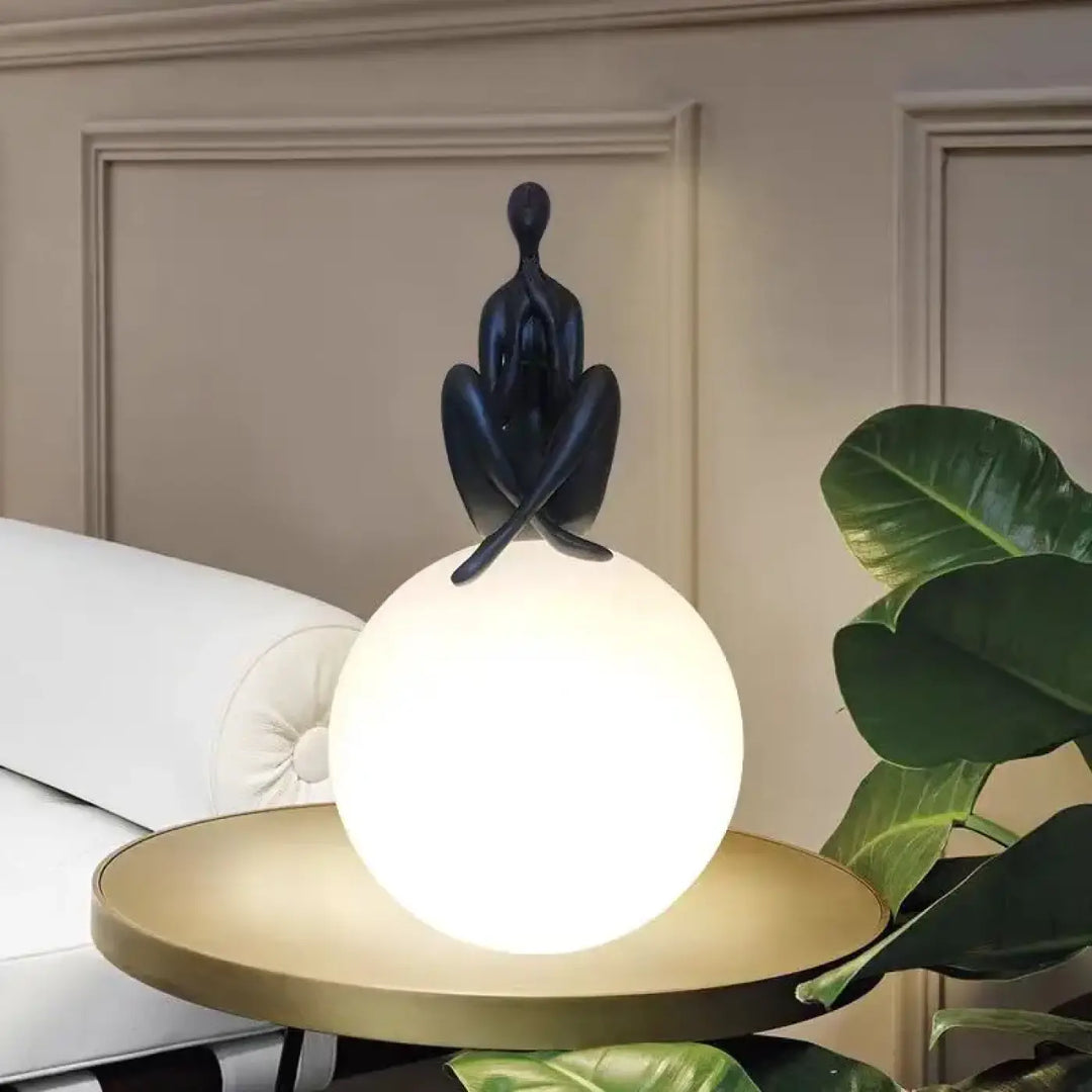 Lampe de table kelya avec silhouette enlacée noire posée sur lumière sphérique lumineuse pour table design moderne