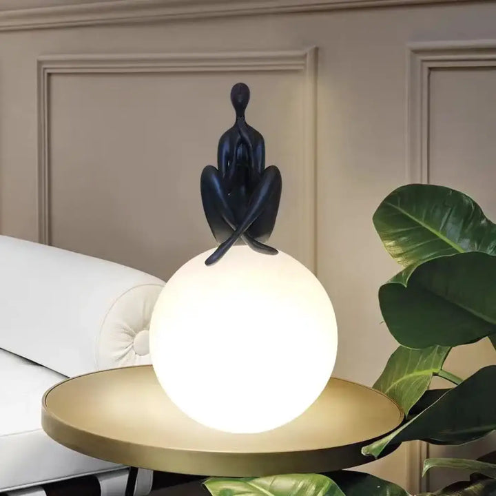 Lampe de table kelya avec silhouette enlacée noire posée sur lumière sphérique lumineuse pour table design moderne