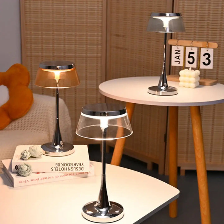 Lampe de table tiah design chrome avec abat-jour transparent en verre diffusant une lumière chaude table led