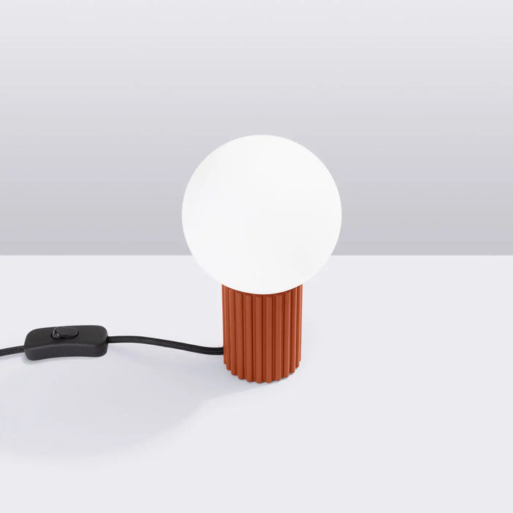 Lampe a poser halo rouge ochra avec abat-jour sphérique en verre blanc mat et base en céramique côtelée terracotta