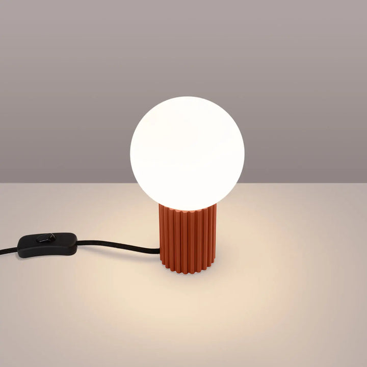 Lampe halo version poser avec globe blanc lumineux sur base cylindrique en terre cuite rouge ochra texturée