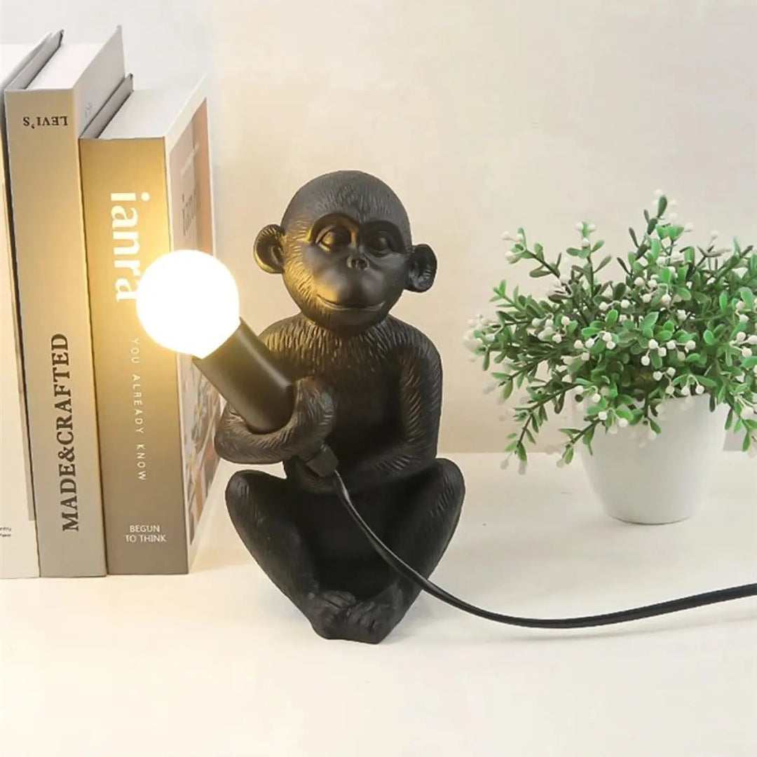 Lampe de table zaboo singe assis en résine noire avec lampe sculpturale singe assis tenant une ampoule allumée