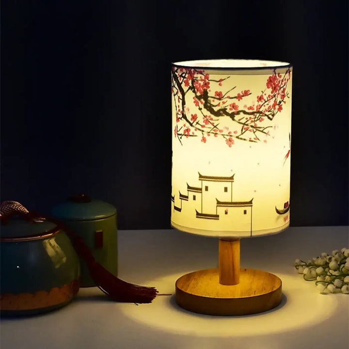 Lampe de table samira avec abat-jour cylindrique tons chauds motifs fleuris et style asiatique sur base en bois