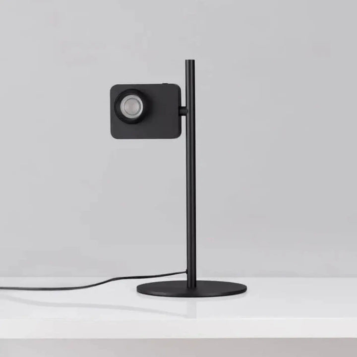 Lampe de table eclia noire minimaliste avec tête carrée et tige élancée pour éclairage directionnel design table
