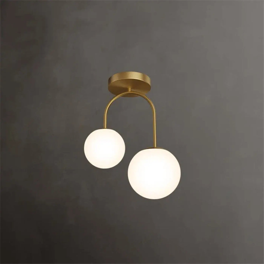 Luminaire plafonnier solia design chic en laiton brossé avec deux globes en verre dépoli pour un style plus classique