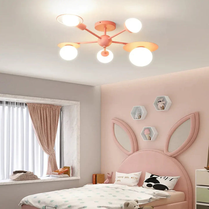 Luminaire plafonnier pastellee avec cinq ampoules sphériques et un hub central design moderne en rose pastel