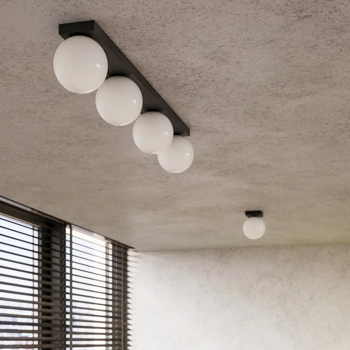 Plafon yoli 6 noir avec quatre globes en verre blanc sphériques, luminaire plafonnier classe à part et design moderne