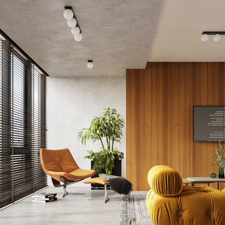 Fauteuil en cuir orange avec pieds en chrome et ottomane assortie sous plafon yoli classe à part