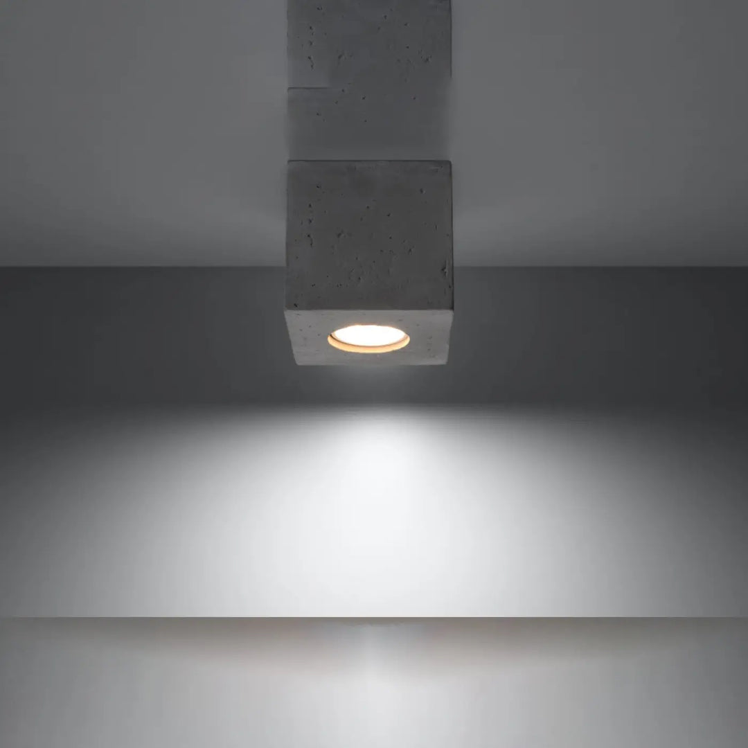 Luminaire plafonnier quad beton gris beton en cube concret avec une lueur circulaire chaude