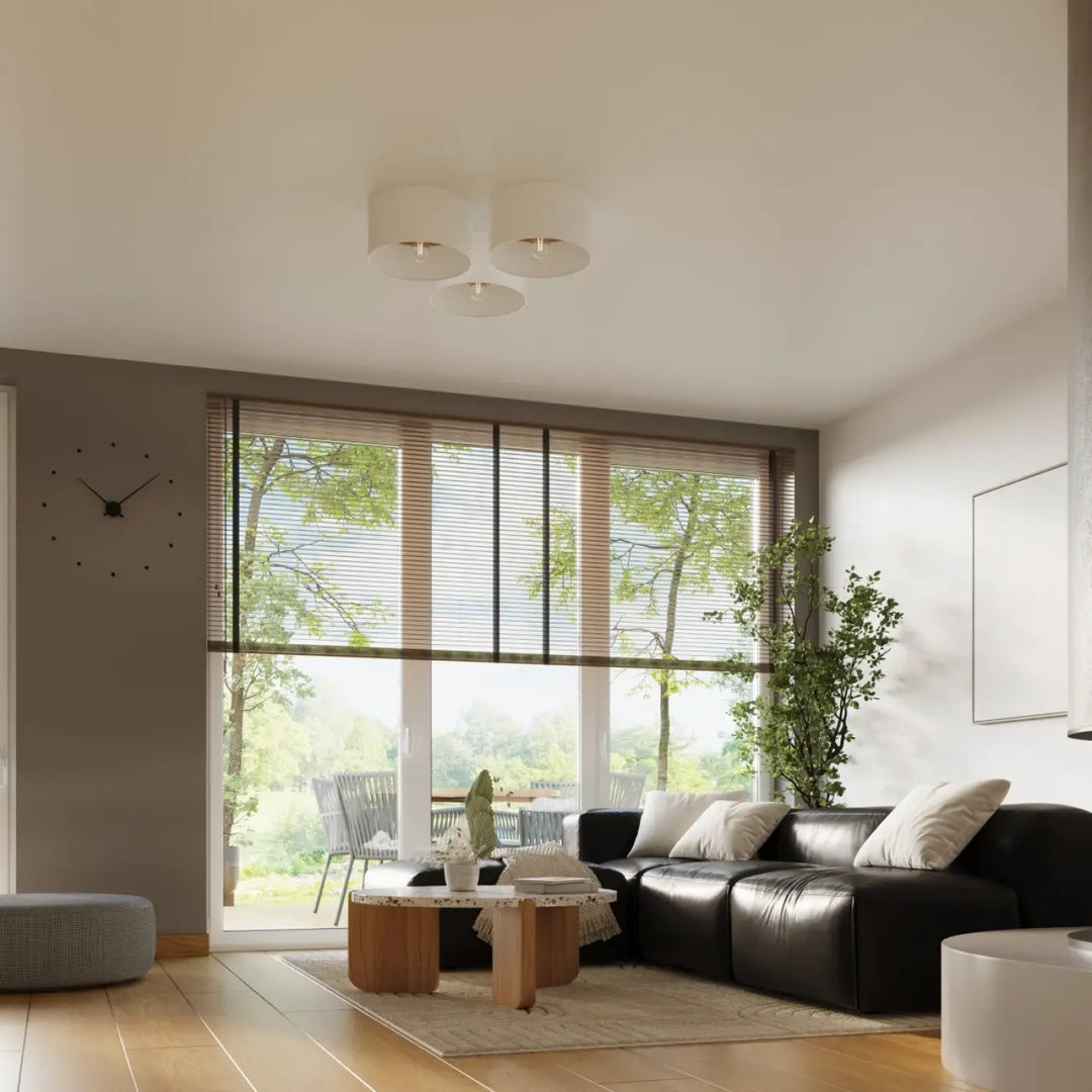 Luminaire plafonnier telesto blanc avec canapé dangle en cuir noir et coussins blancs pour une combinaison parfaite design minimaliste