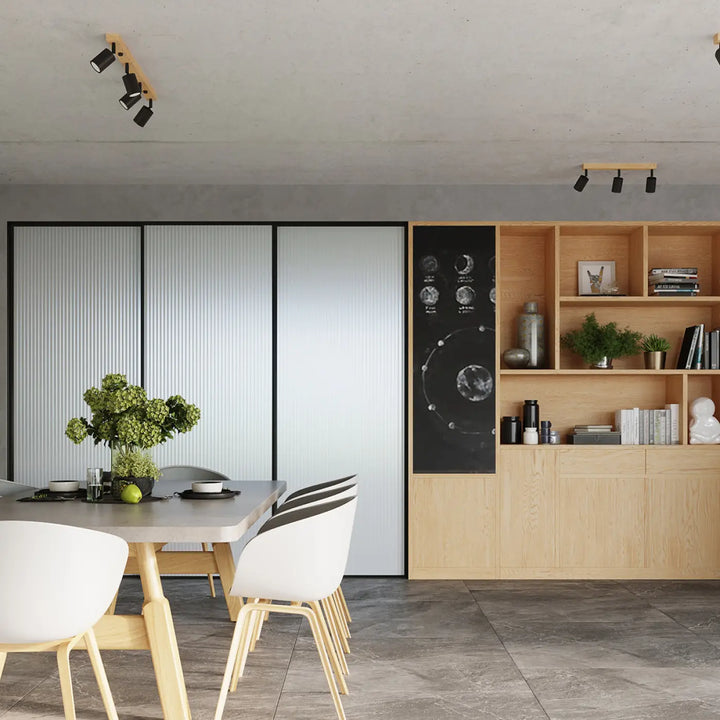 Table à manger design moderne avec plateau en béton et pieds en bois clair sous plafonnier verdo noir