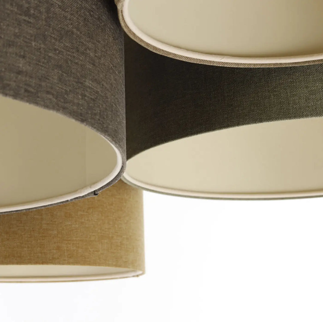 Luminaire plafonnier avec trois abat-jours cylindriques en tissu naturel texturé beige, gris foncé et noir avec intérieur écru