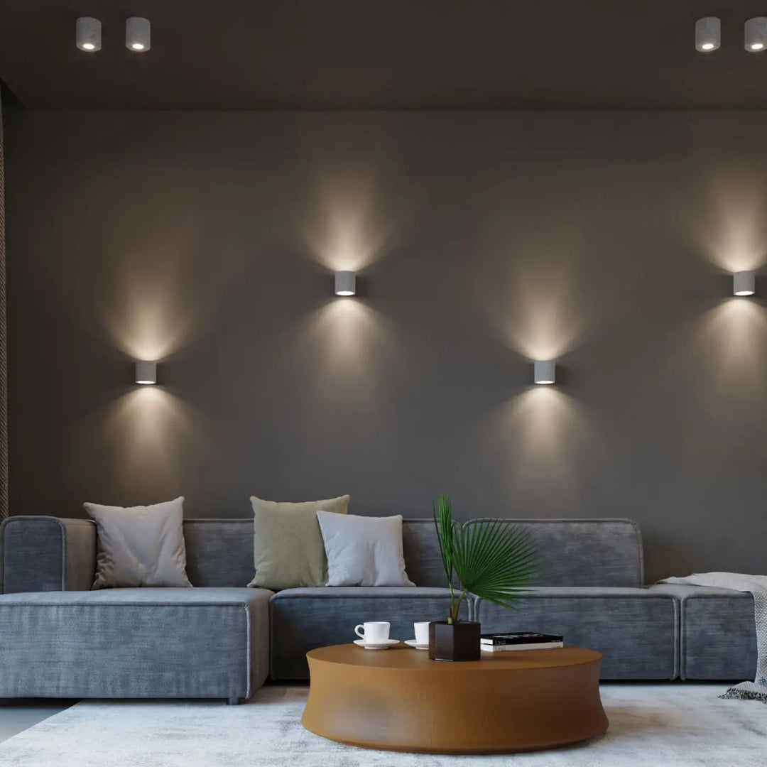Luminaire plafonnier orbis béton avec appliques murales minimalistes blanches cylindriques et éclairage chaud ciblé