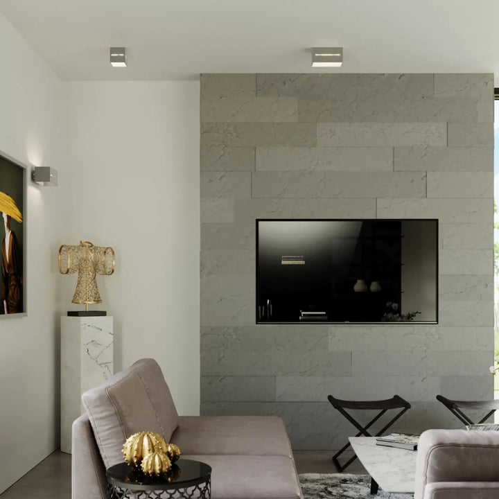 Luminaire plafonnier lobo 2 gris installé sur un mur en marbre gris avec un spectacle lumineux à perforation linéaire