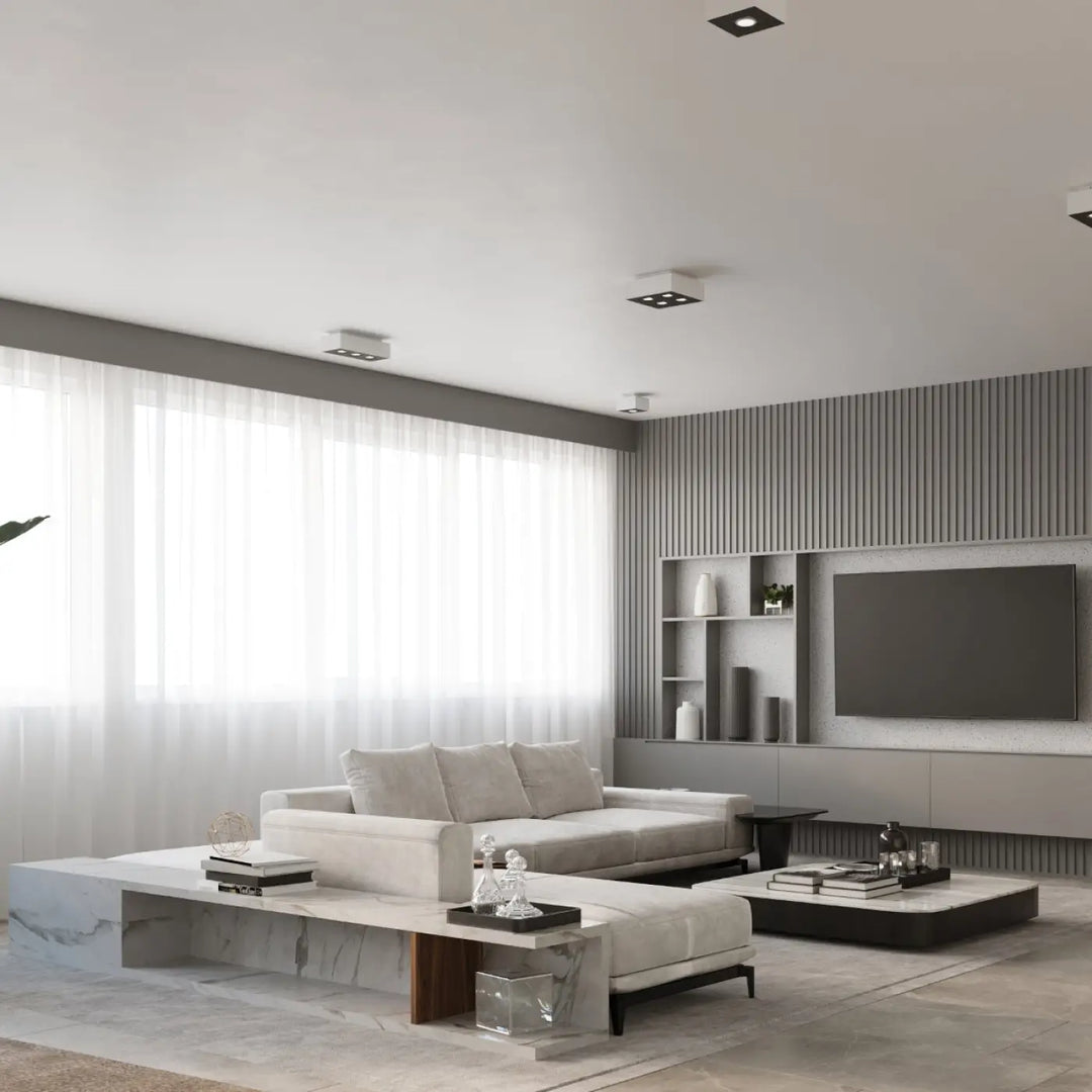 Luminaire plafonnier moderne mono blanc dans un salon minimaliste avec canapé blanc et tables en marbre
