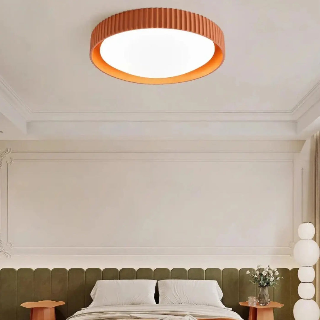 Luminaire plafonnier stria orange à texture côtelée avec reliefs graphiques diffusant une lumière chaleureuse