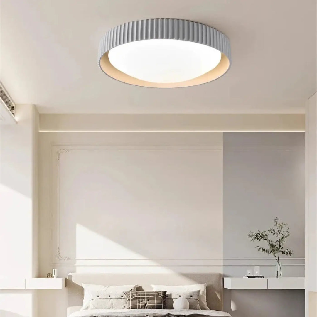 Luminaire plafonnier stria en design circulaire avec anneau gris cannelé et éclairage blanc diffus pour reliefs graphiques