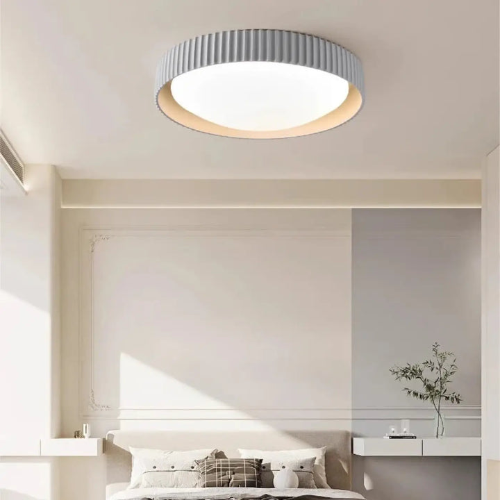 Luminaire plafonnier stria en design circulaire avec anneau gris cannelé et éclairage blanc diffus pour reliefs graphiques
