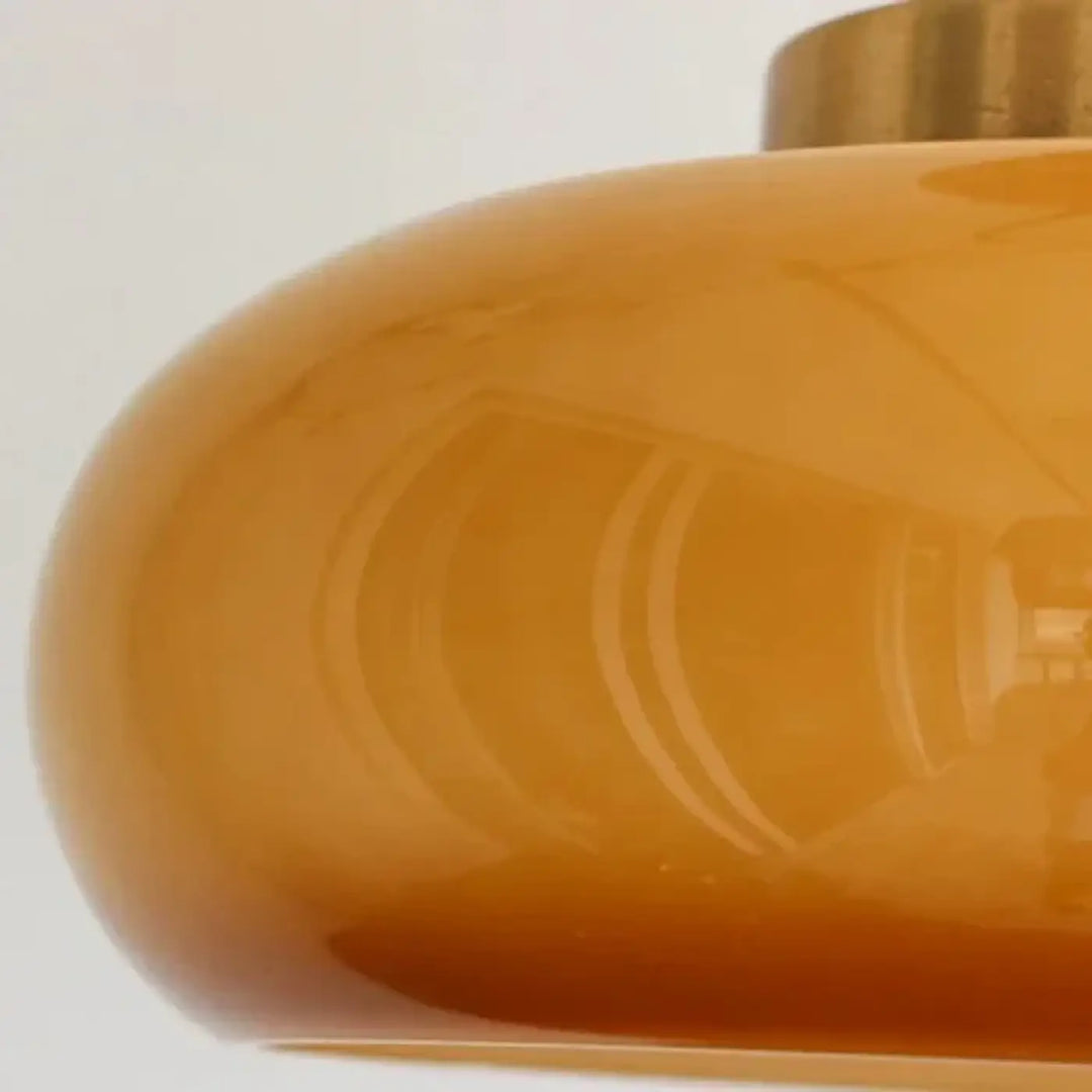 Luminaire plafonnier moderne solis avec abat-jour en verre ambré lisse et finition en laiton élégant