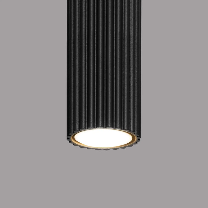 Luminaire plafonnier karbon 20 noir avec design minimaliste cylindre noir nervuré et base circulaire éclairée blanc chaud