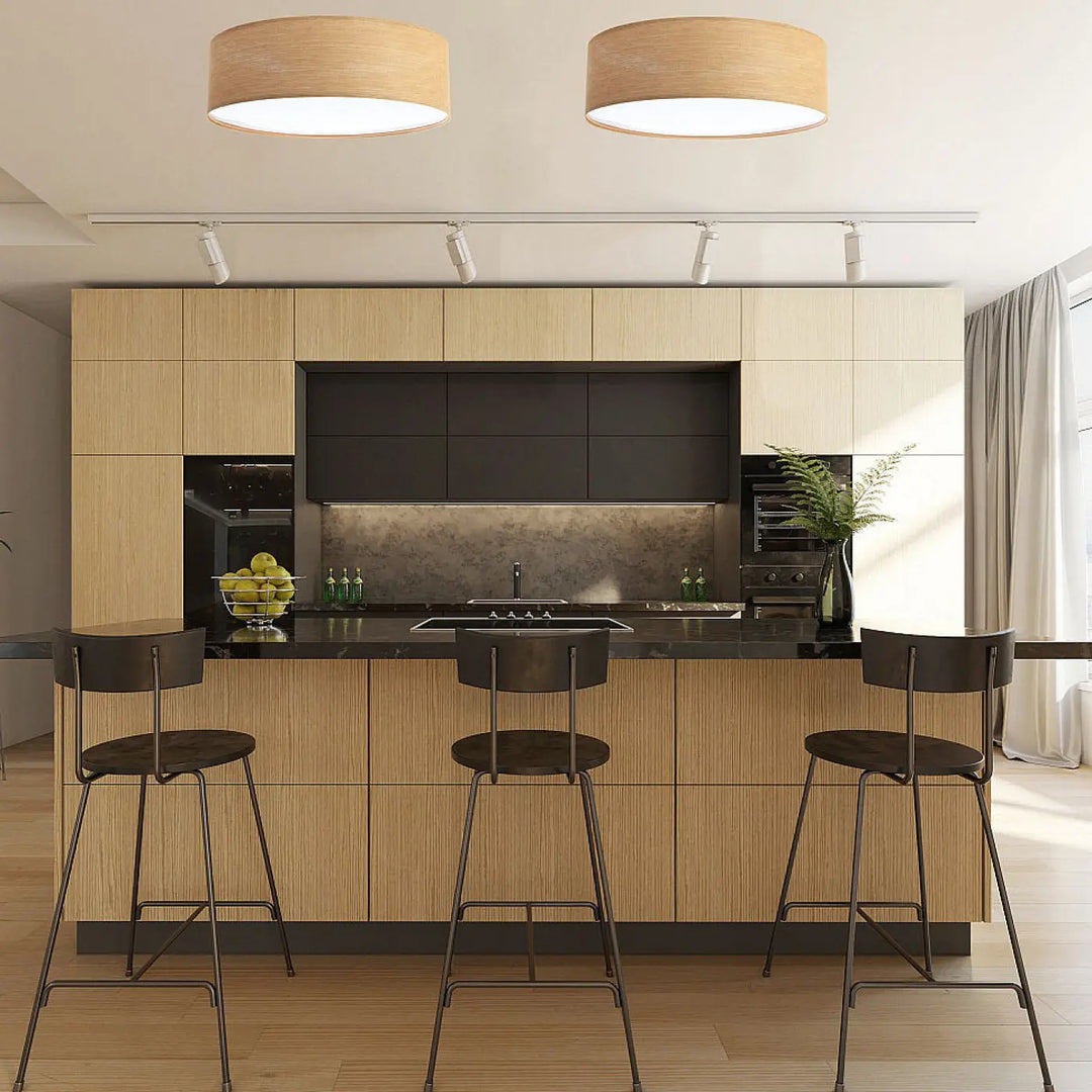 Luminaire plafonnier mesh en tissu caramel installé dans une cuisine moderne avec plans de travail foncés et tabourets noirs