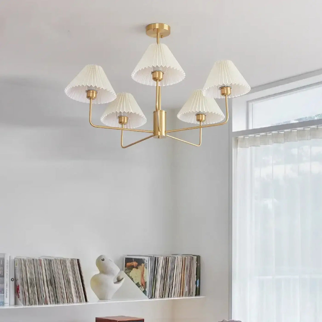 Suspension luminaire sandrya avec cinq abat-jours plissés en tissu blanc et structure dorée idéale pour salle à manger