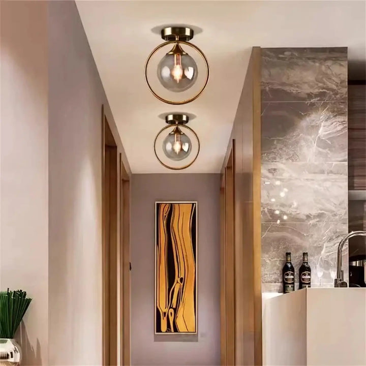 Deux plafonniers chic orbane avec cadre anneau doré et boules lumineuses en verre transparent
