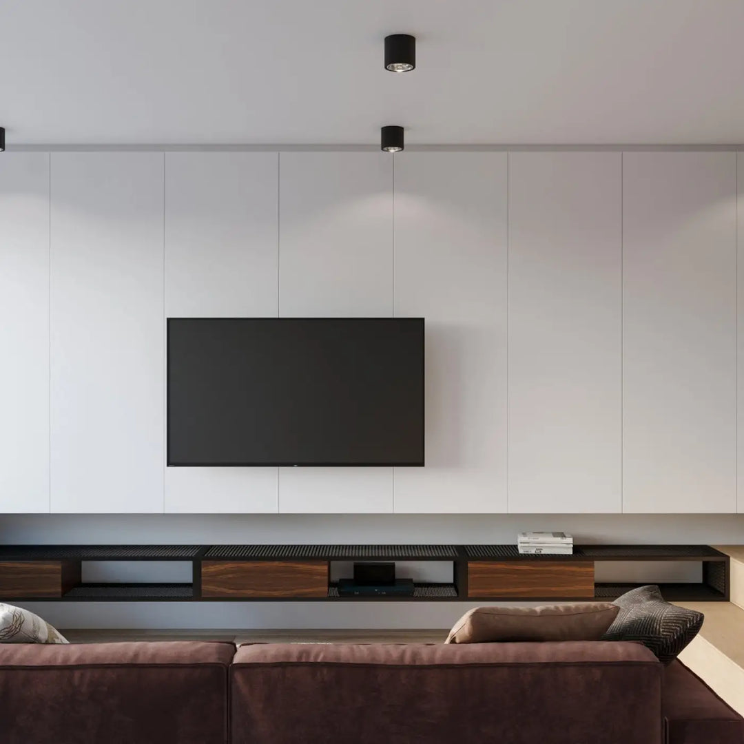 Plafonnier tiube noir moderne à forme minimaliste installé sur un mur blanc avec télévision écran plat noire