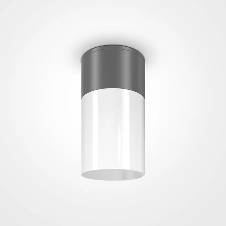 Plafonnier extérieur willis cylindrique avec corps en verre blanc translucide et dessus métallique gris mat offrant lumière dirigée