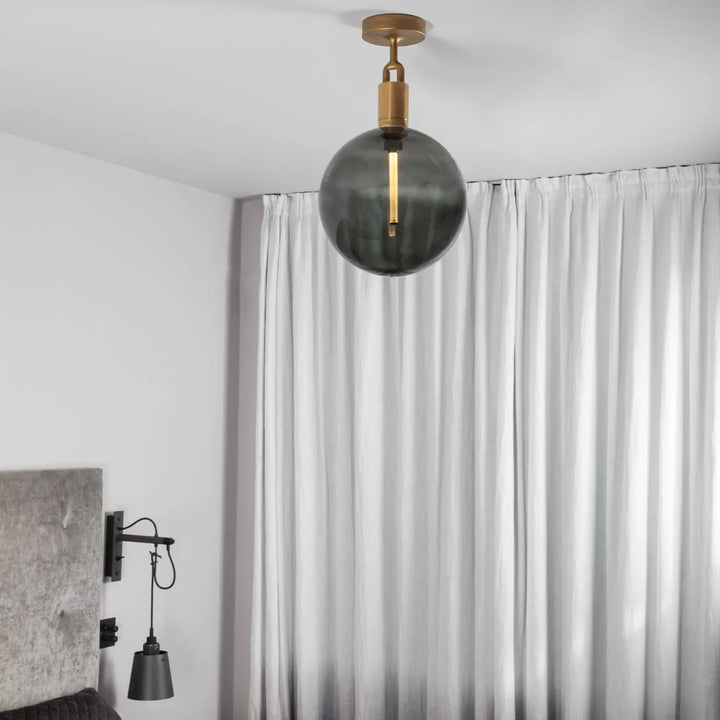 Plafonnier Forked Large à globe fumé, finition laiton, dans un intérieur #couleur_dor